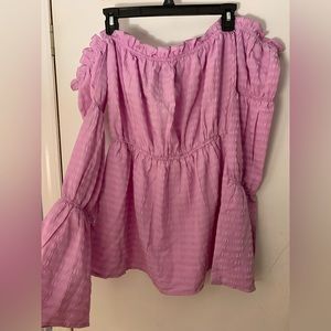 A pink off a shoulder shirt